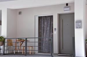 a balcony with a door and a table and chairs at In&Out in Nafplio