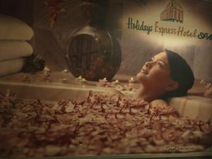 een poster van een vrouw in een badkuip gevuld met beeldjes bij Holidays Express Hotel in Caïro