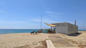 a group of people sitting on the beach at Arran de Mar Cambrils in Cambrils