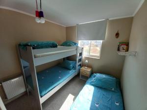 a bedroom with two bunk beds and a window at Algarrobo Laguna Bahía Espectacular Departamento in Algarrobo