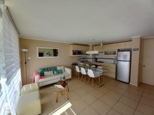 sala de estar y cocina con sofá y mesa en Algarrobo Laguna Bahía Espectacular Departamento, en Algarrobo