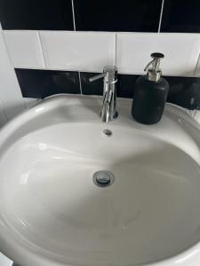 a white bathroom sink with a soap dispenser on it at Stunning 3 bedroom property- Large Rooms in London