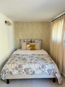 a bedroom with a large bed with a floral bedspread at Magnifique Studio Tropézien à 300 m de la plage (parking gratuit) in Saint-Tropez