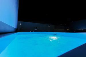 una grande piscina illuminata di notte di Ageri Suite a Vóthon