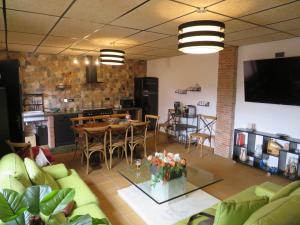 a living room with a couch and a table and a kitchen at Casa Rural El Pescador 