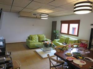 un salon avec une table et des meubles verts dans l'établissement Casa Rural El Pescador, à Mezalocha 11 autres photos