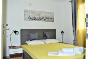 a bedroom with a yellow bed with towels on it at Apartment MMP in Kotor