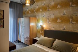a bedroom with a bed and a wall with a refrigerator at Hotel Spring in Rimini