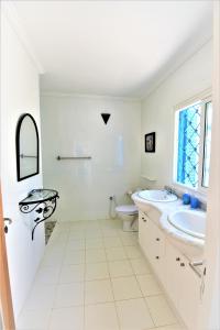 La salle de bains blanche est pourvue d'un lavabo et de toilettes. dans l'établissement VILLA KIKA ZARZIS, LOCATION CHAMBRES D'HÔTES en TUNISIE, à Zarzis
