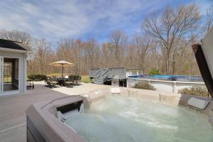 a large hot tub in a yard with a patio at Luxe Lrg Pocono House for 18 Hot Tub/Gameroom/Pool in Kunkletown