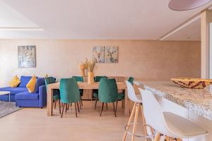 comedor con sofá azul, mesa y sillas en Appartement moderne central Prestigia, en Marrakech