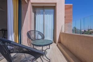 balcón con mesa y sillas en Appartement moderne central Prestigia, en Marrakech