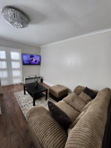 - un salon avec un canapé et une table dans l'établissement Home away from Home, à Woolwich