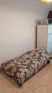 - un lit dans l'angle d'une chambre avec un réfrigérateur dans l'établissement Alojamiento ruta 3, à Trelew