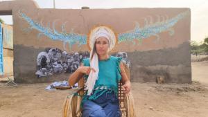 una mujer sentada en una silla frente a una pared en Humansofupperegyt, en Luxor