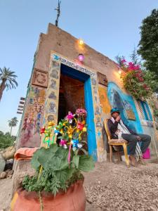 a man sitting in a chair in front of a building at Humansofupperegyt in Luxor