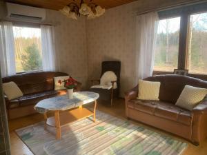 uma sala de estar com sofás de couro e uma mesa de centro em Kodikas Mökki em Ähtäri