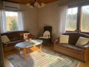 a living room with leather couches and a coffee table at Kodikas Mökki in Ähtäri