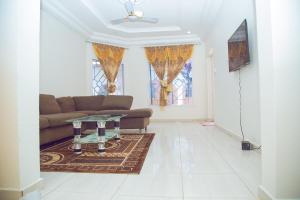 a living room with a couch and a table at SeneGambia Beach Apartments in Bijilo