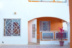 Bijilo的住宿－SeneGambia Beach Apartments，一座有门和盆栽的建筑