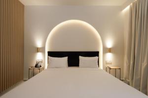 a bedroom with a large white bed with an arch overhead at Alley Boutique Hotel and Spa in Argostoli