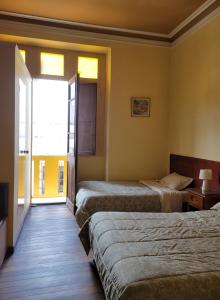 a hotel room with two beds and a window at Inka Roots Hostel in Arequipa