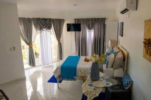 a bedroom with a bed and a couch and a table at Royal Terrace IV (King) in San Felipe de Puerto Plata