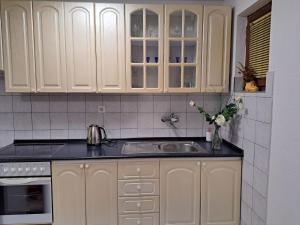 a kitchen with white cabinets and a sink at Apartmani Bosna Visoko in Visoko