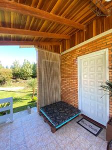 a porch with a white door and a patio at Casa no Vale dos Vinhedos em Bento Gonçalves in Bento Gonçalves