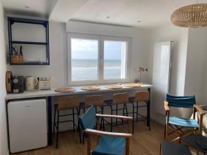 a kitchen with a breakfast bar with a view of the ocean at L’Abri Cotier - Appartement face mer 2/4 personnes in Fort-Mahon-Plage