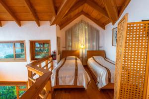 two beds in a room with wooden ceilings at Balam Ya in Panajachel