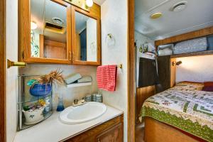 a bathroom with a sink and a bed in an rv at Yuma Getaway with Pool Access, 5 Mi to Lutes Casino! in Yuma