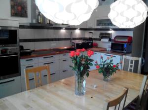 a kitchen with a wooden table with flowers in a vase at Hostel Hamburg in Hamburg