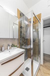 uma casa de banho com um lavatório e um chuveiro em Duomo a 10 minuti - Self check In Metro a 3 minuti a piedi em Milão