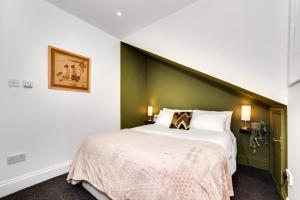 a bedroom with a large bed with a green headboard at The Penthouse 3 Minutes To The Beach, Super Comfy Beds, Part of Burlington-Escapes in Brighton & Hove