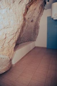 a room with a stone wall and a wooden floor at Hostel Blue Lagoon in La Mareta