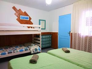 a bedroom with two bunk beds and a blue door at Hostel Blue Lagoon in La Mareta