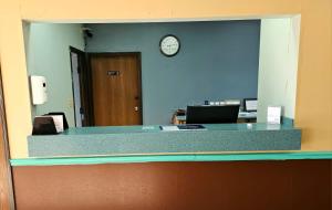 an office with a reception desk with a clock on the wall at Budget Inn, Hwy 41 in Barnesville