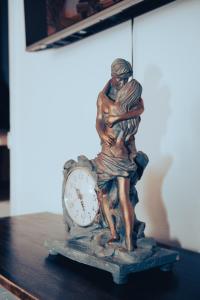posąg człowieka i zegar na stole w obiekcie Hostel Blue Lagoon w mieście La Mareta