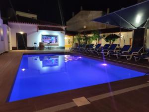 una piscina notturna con illuminazione blu di Luxury Palm Suites a Reguengos de Monsaraz