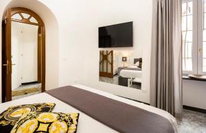 a bedroom with a bed and a television on the wall at Suite Incentro Salerno in Salerno