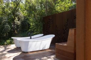 a bath tub sitting on a deck next to a fence at Tussock Hill Vineyard Retreats in Christchurch