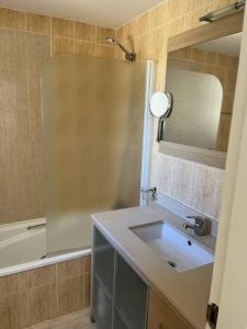 een badkamer met een wastafel, een spiegel en een bad bij Apartment close to Marbella in Cabopino