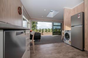 a kitchen with a washer and dryer and a living room at Starbright Townhouse in Twizel