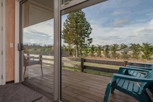a sliding glass door to a deck with a chair at Starbright Townhouse in Twizel