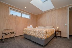 a bedroom with a bed and a skylight at Starbright Townhouse in Twizel