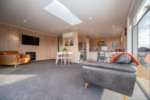 a living room with a couch and a kitchen at Starbright Townhouse in Twizel