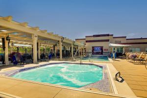 a large swimming pool in a building with a patio at Drury Plaza Hotel in Santa Fe in Santa Fe