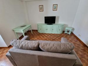 uma sala de estar com um sofá e uma mesa em Apartamentos Garrett em Horta