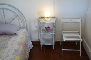 a bedroom with a bed and a lamp and a chair at Casinha Robusto 